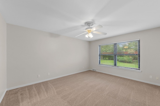 carpeted spare room with ceiling fan