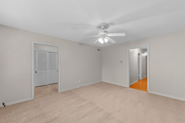 empty room with light colored carpet and ceiling fan