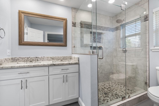 bathroom featuring walk in shower, vanity, and toilet