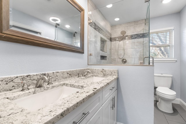 bathroom featuring vanity, a shower with shower door, tile patterned floors, and toilet