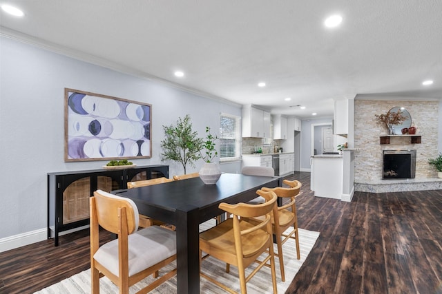 dining area with ornamental molding, a fireplace, and dark hardwood / wood-style flooring