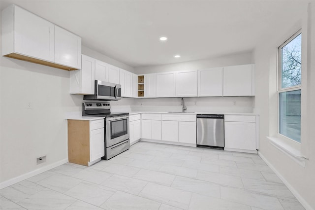 kitchen with stainless steel appliances, sink, and white cabinets