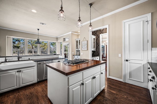 kitchen with sink, wooden counters, decorative light fixtures, appliances with stainless steel finishes, and white cabinets