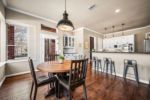 dining space featuring ornamental molding and dark hardwood / wood-style floors