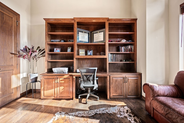 home office featuring built in desk and hardwood / wood-style floors