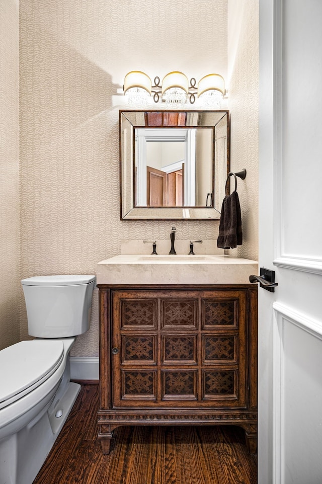 bathroom featuring vanity, wood-type flooring, and toilet