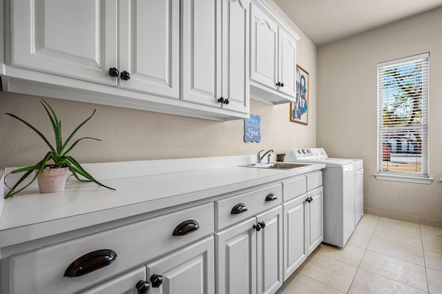 washroom with sink, light tile patterned floors, cabinets, and independent washer and dryer