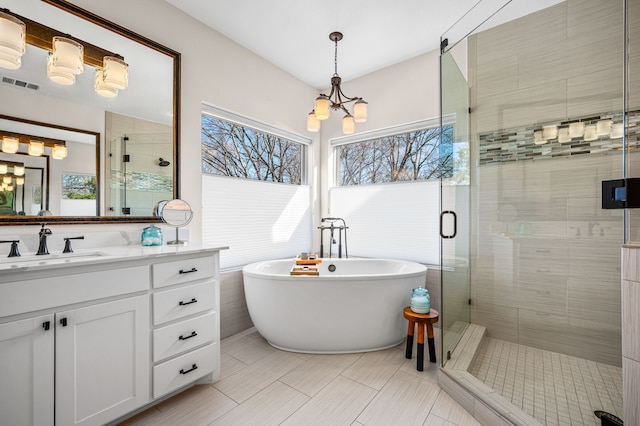 bathroom with plus walk in shower, vanity, and a chandelier