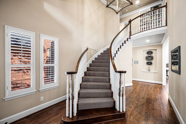 foyer entrance with crown molding, dark hardwood / wood-style flooring, and a high ceiling