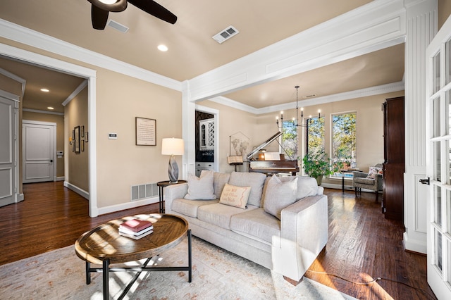 living room with hardwood / wood-style floors, crown molding, and ceiling fan with notable chandelier