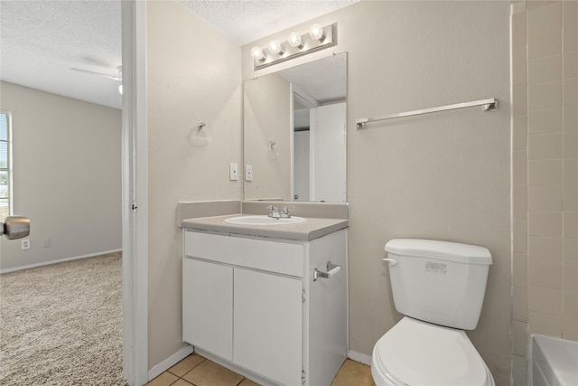 bathroom with vanity, toilet, tile patterned flooring, and a textured ceiling