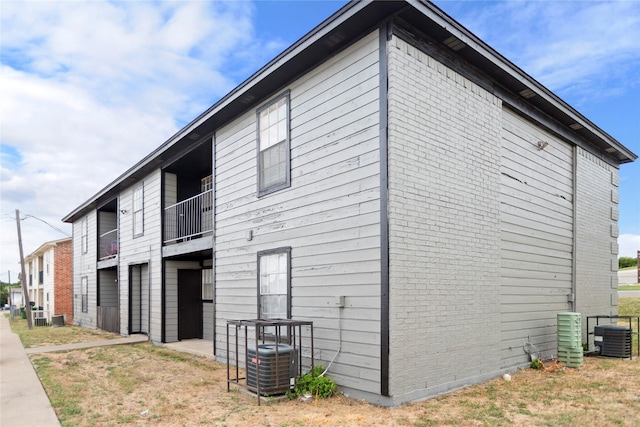 view of property exterior featuring a balcony and central AC