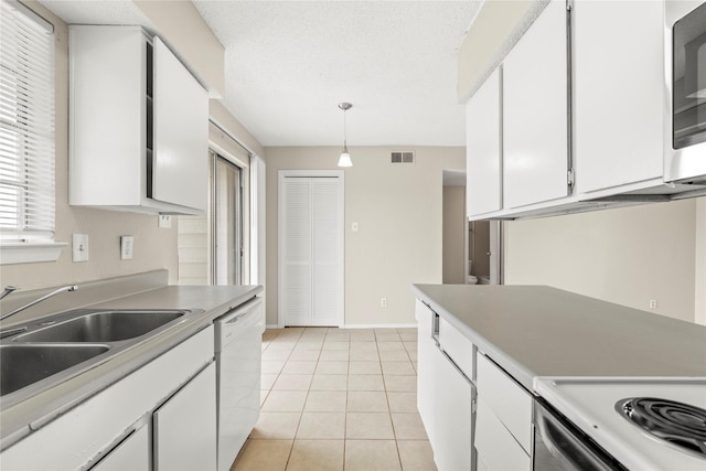 kitchen with pendant lighting, sink, dishwasher, white cabinetry, and light tile patterned flooring