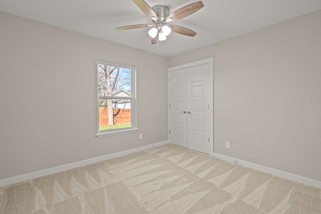 carpeted empty room featuring ceiling fan