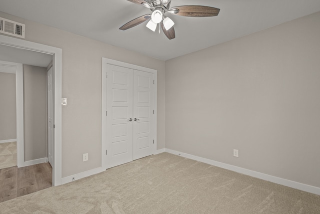 unfurnished bedroom with ceiling fan, light colored carpet, and a closet