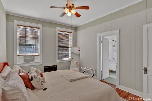 bedroom with wood-type flooring, ceiling fan, and ensuite bath