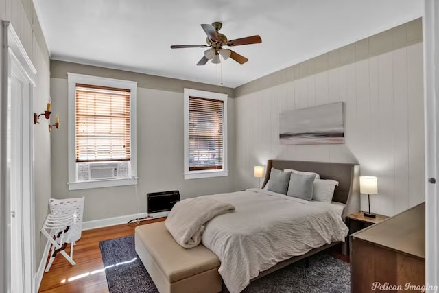 bedroom with cooling unit, ceiling fan, and wood-type flooring