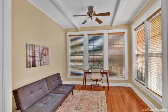 sitting room with a healthy amount of sunlight, ceiling fan, hardwood / wood-style flooring, and beamed ceiling