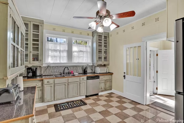 kitchen with sink, decorative backsplash, ornamental molding, stainless steel dishwasher, and ceiling fan