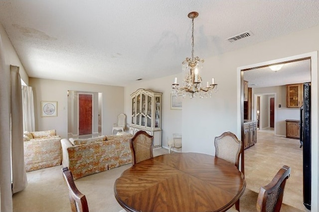 dining area featuring light carpet and a textured ceiling