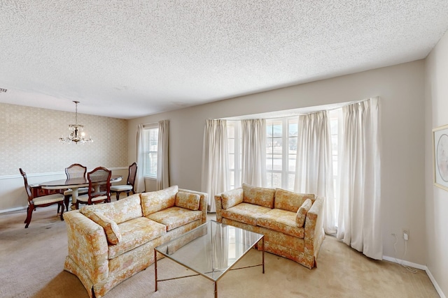 living room with light carpet, wallpapered walls, a textured ceiling, and baseboards