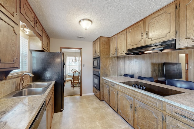 kitchen featuring sink, backsplash, black appliances, and a textured ceiling