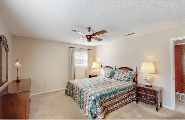 bedroom with a textured ceiling, visible vents, and light colored carpet