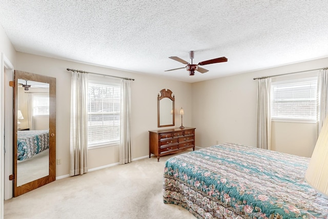 bedroom with ceiling fan, a textured ceiling, baseboards, and carpet flooring