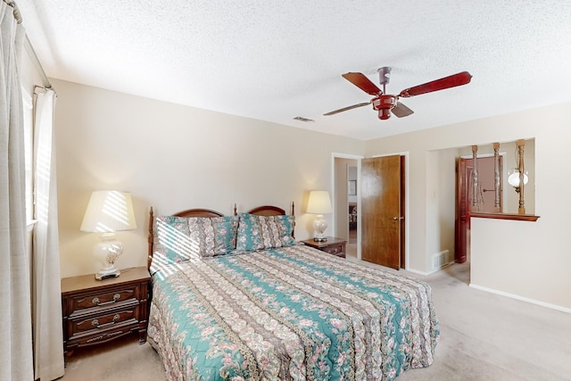 bedroom featuring a textured ceiling, carpet, visible vents, and baseboards