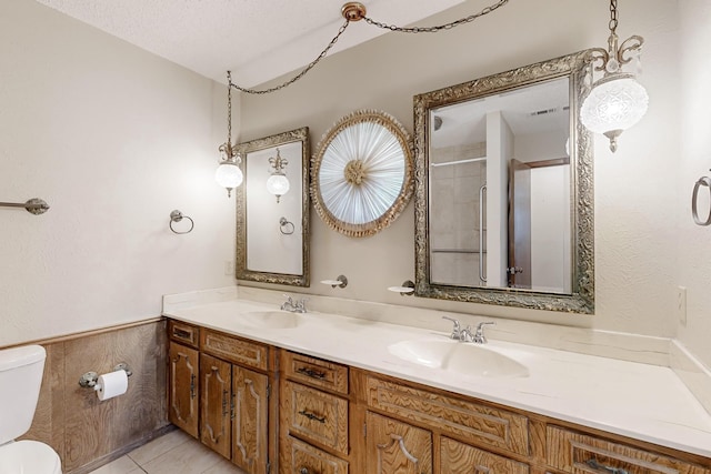 full bath featuring tile patterned flooring, a sink, toilet, and double vanity