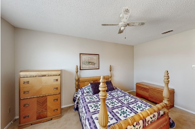 bedroom with light carpet, a textured ceiling, visible vents, and a ceiling fan