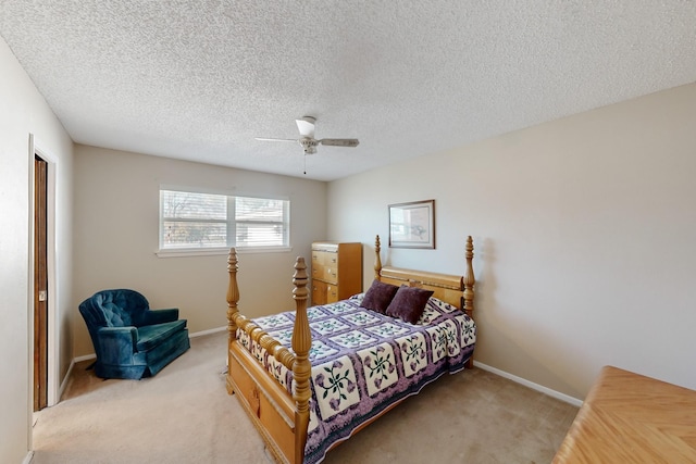 bedroom featuring a textured ceiling, light colored carpet, and ceiling fan