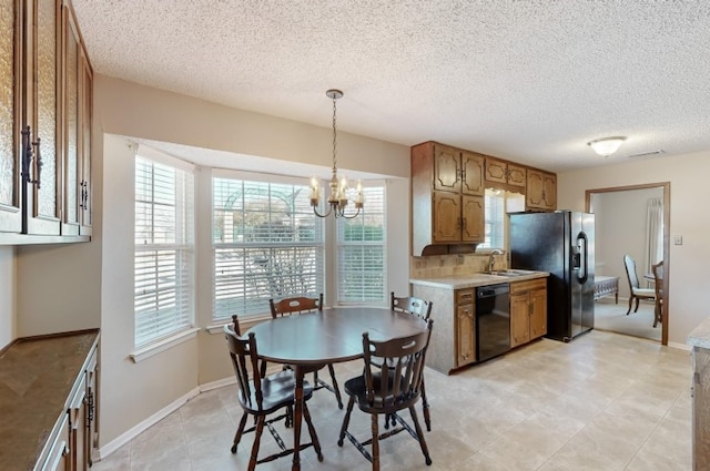 kitchen with a chandelier, visible vents, light countertops, brown cabinets, and black appliances