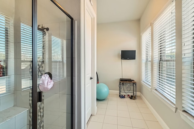 exercise room featuring light tile patterned floors and a healthy amount of sunlight