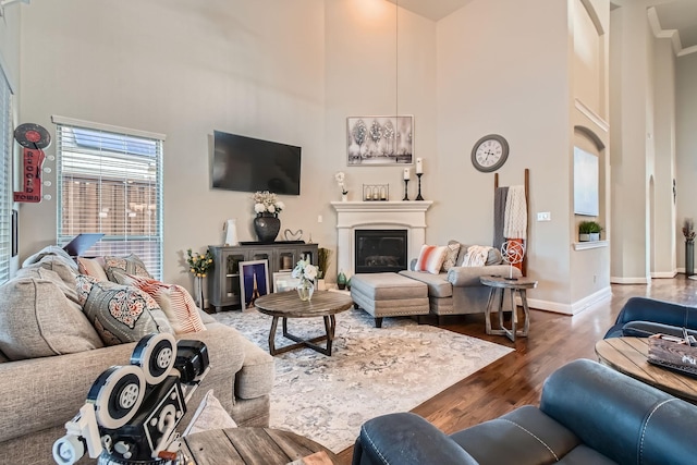 living room with a towering ceiling and dark hardwood / wood-style floors