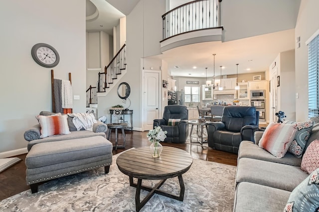 living room featuring a high ceiling, dark wood-type flooring, and a chandelier