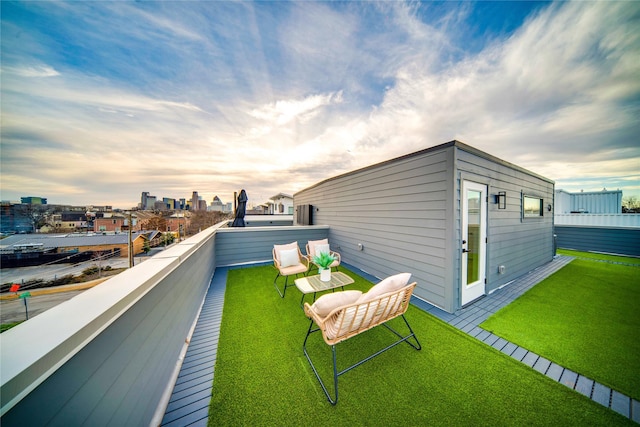 yard at dusk featuring a balcony