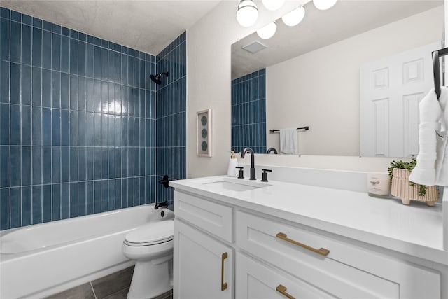 full bathroom featuring tiled shower / bath combo, vanity, tile patterned floors, and toilet