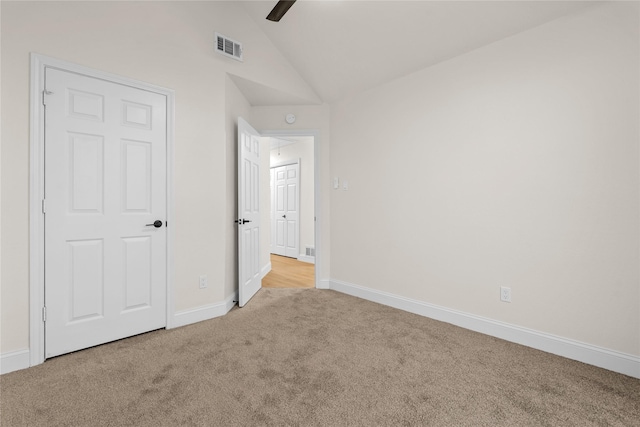 unfurnished bedroom with vaulted ceiling, light carpet, and ceiling fan