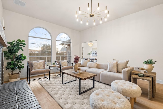 living room with an inviting chandelier and light hardwood / wood-style flooring