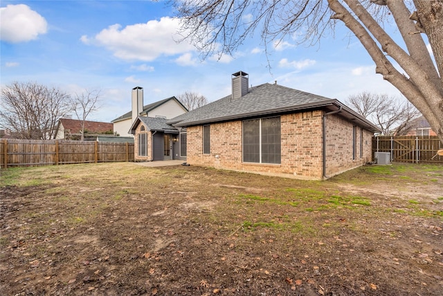 rear view of house featuring central AC unit, a patio area, and a lawn