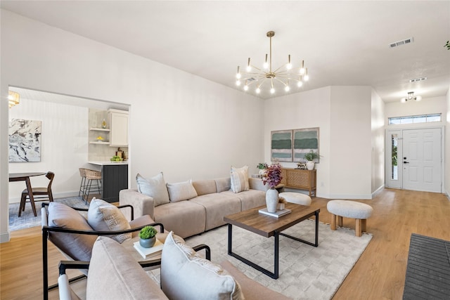 living room featuring a chandelier and light hardwood / wood-style floors