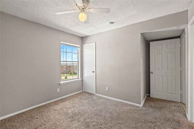 spare room featuring ceiling fan, a textured ceiling, and carpet flooring