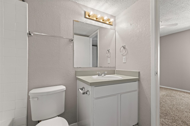 bathroom featuring vanity, toilet, and a textured ceiling