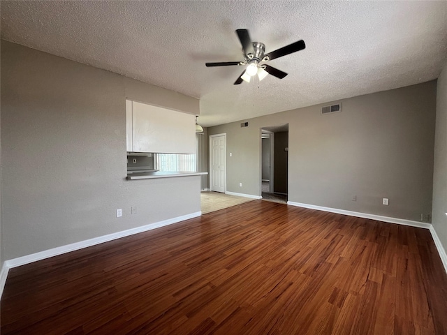 unfurnished living room featuring ceiling fan, wood-type flooring, and a textured ceiling