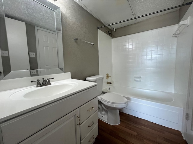 full bathroom with toilet, a textured ceiling, vanity, tiled shower / bath combo, and hardwood / wood-style floors