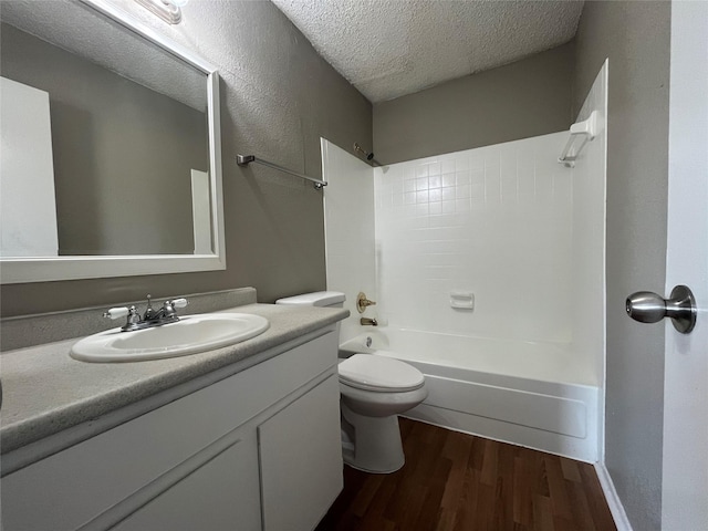 full bathroom featuring hardwood / wood-style flooring, vanity, a textured ceiling, shower / bathtub combination, and toilet