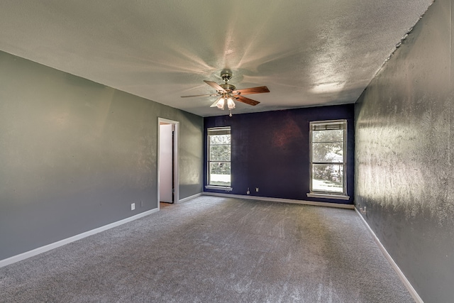 carpeted empty room with ceiling fan and a textured ceiling