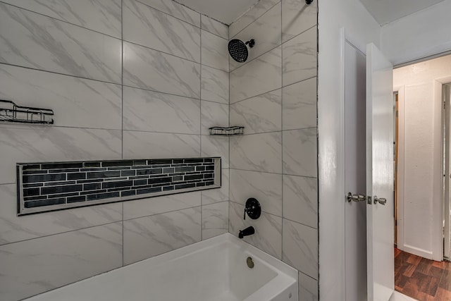 bathroom featuring tiled shower / bath combo and hardwood / wood-style flooring