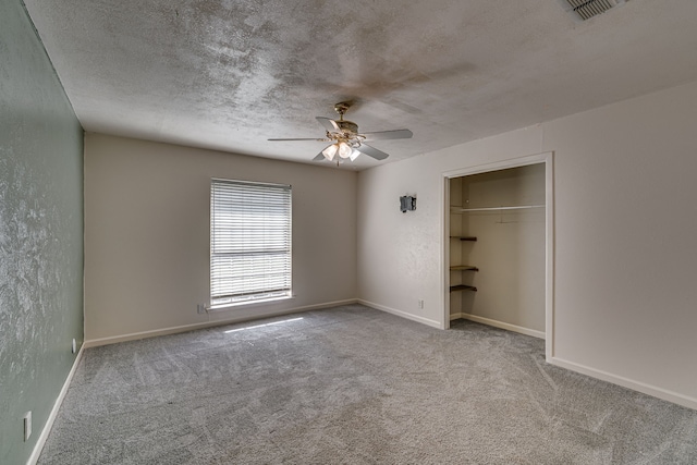 unfurnished bedroom featuring light carpet, ceiling fan, a closet, and a textured ceiling